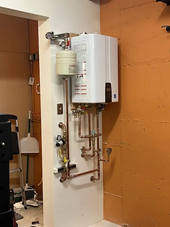 Plumbing technician inspecting water heater connections in Tumwater